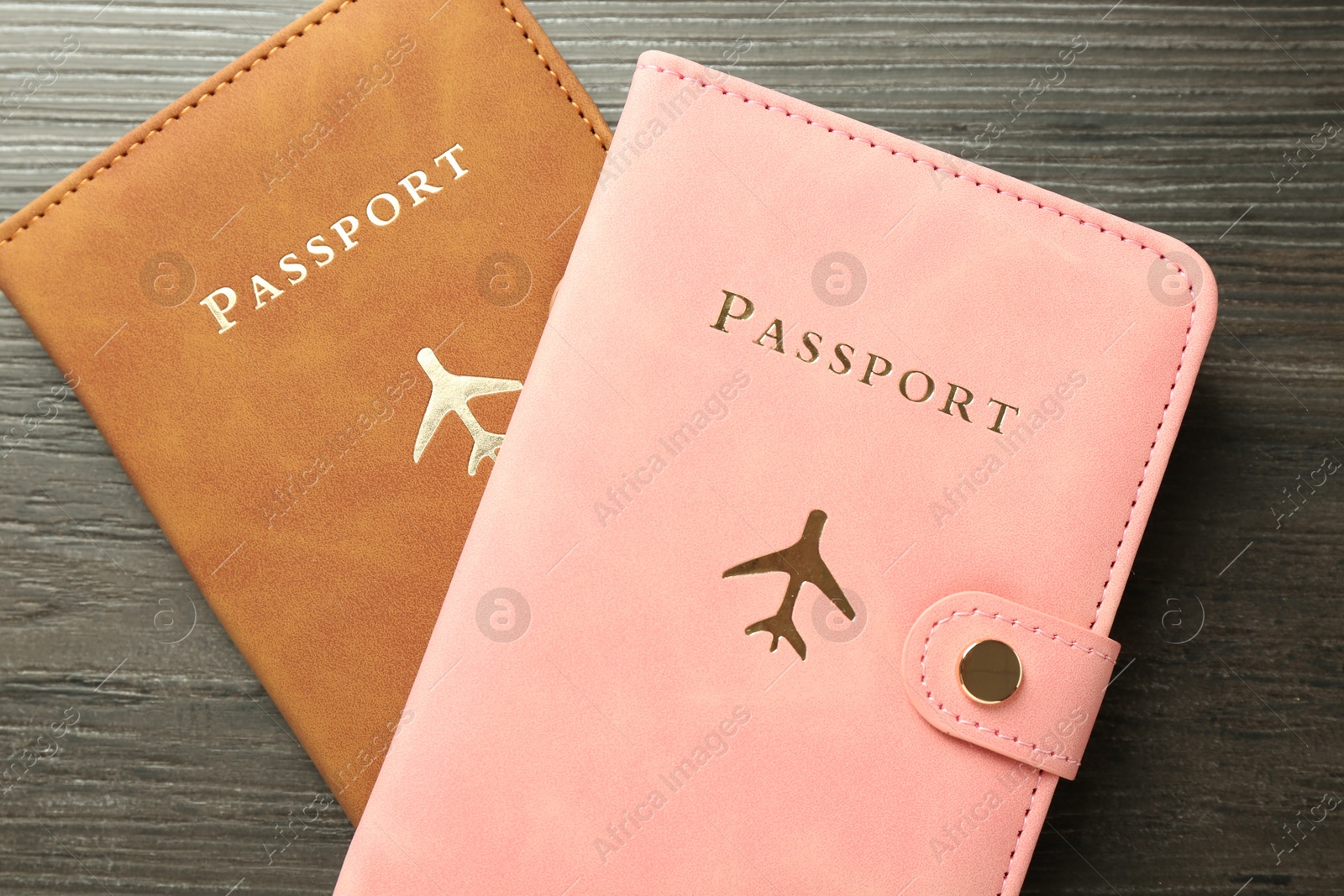 Photo of Passports in color covers on wooden table, top view