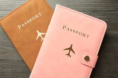 Photo of Passports in color covers on wooden table, top view