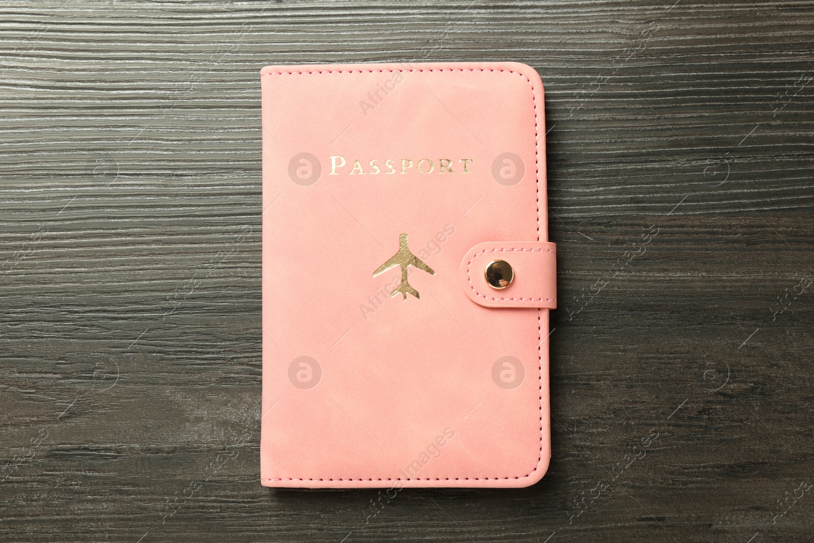 Photo of Passport in pink cover on wooden table, top view