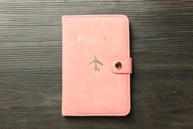 Photo of Passport in pink cover on wooden table, top view