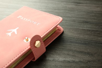 Photo of Passport in pink cover on wooden table, closeup. Space for text