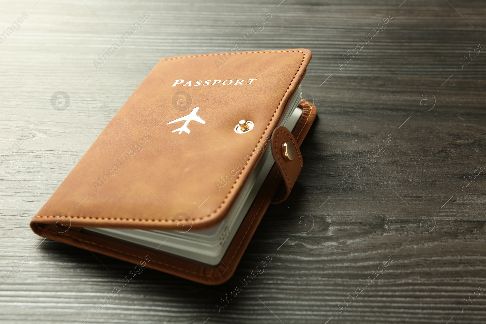 Photo of Passport in brown cover on wooden table