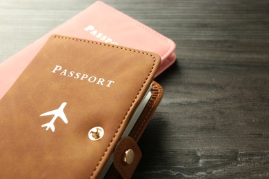 Photo of Passports in color covers on wooden table, closeup. Space for text