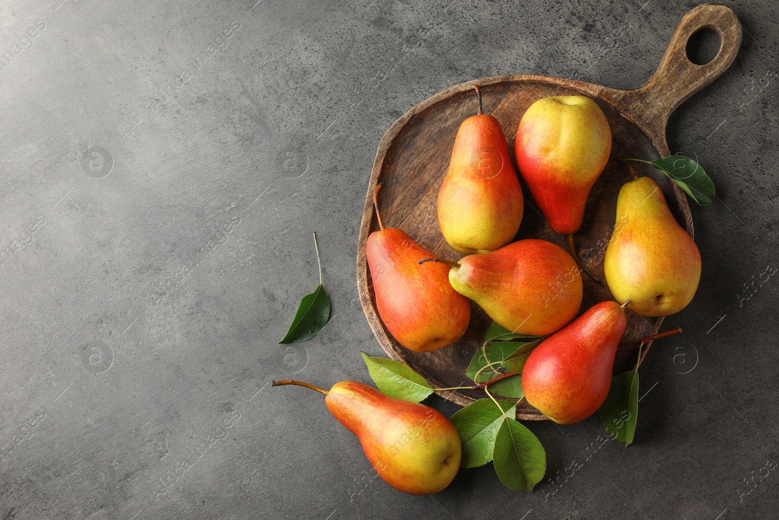 Photo of Ripe juicy pears on grey table, flat lay. Space for text