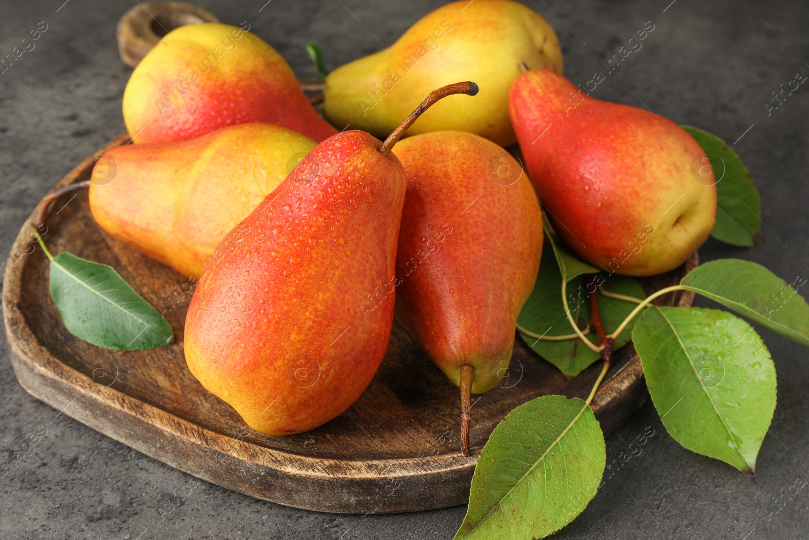 Photo of Ripe juicy pears on grey table, closeup