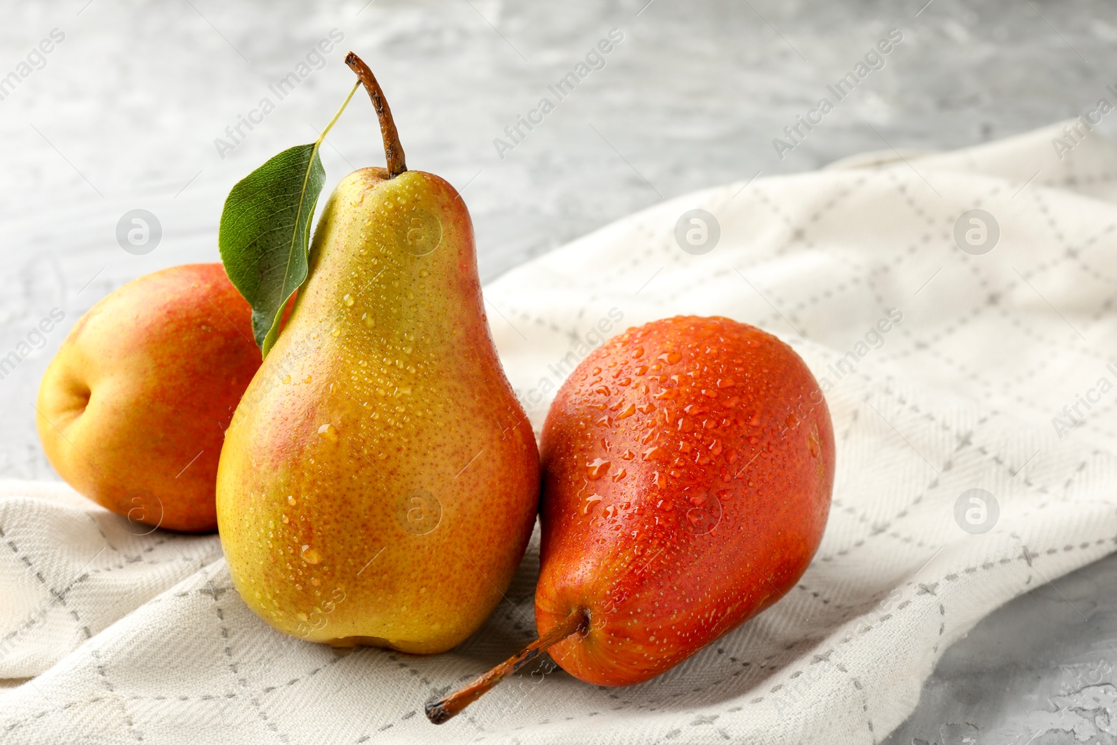 Photo of Ripe juicy pears on grey table, closeup