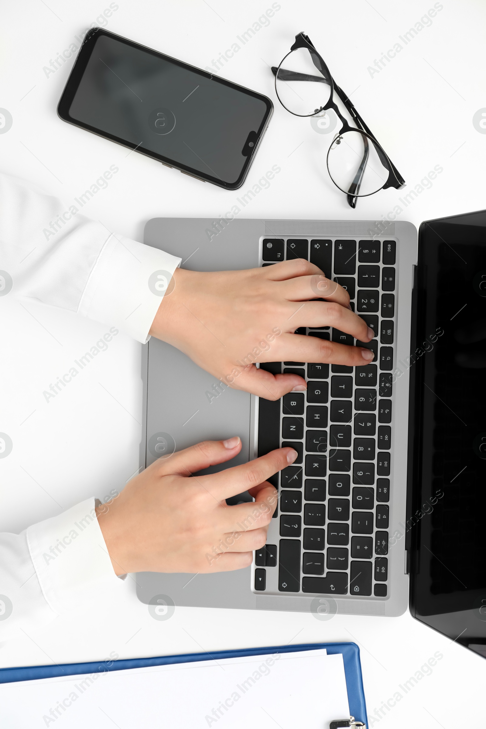 Photo of Businesswoman using laptop at white table indoors, top view. Modern technology