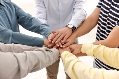 Photo of Teamwork. Group of employees joining hands in office, closeup