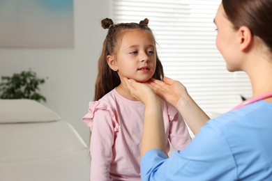 Photo of Doctor examining girl's throat in clinic during appointment