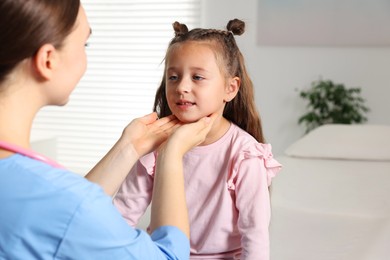 Photo of Doctor examining girl's throat in clinic during appointment