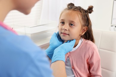 Doctor examining girl's throat in clinic during appointment