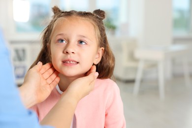 Photo of Doctor examining girl's throat in clinic during appointment