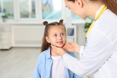 Doctor examining girl's throat in clinic during appointment