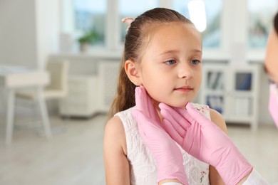 Photo of Doctor examining girl's throat in clinic during appointment