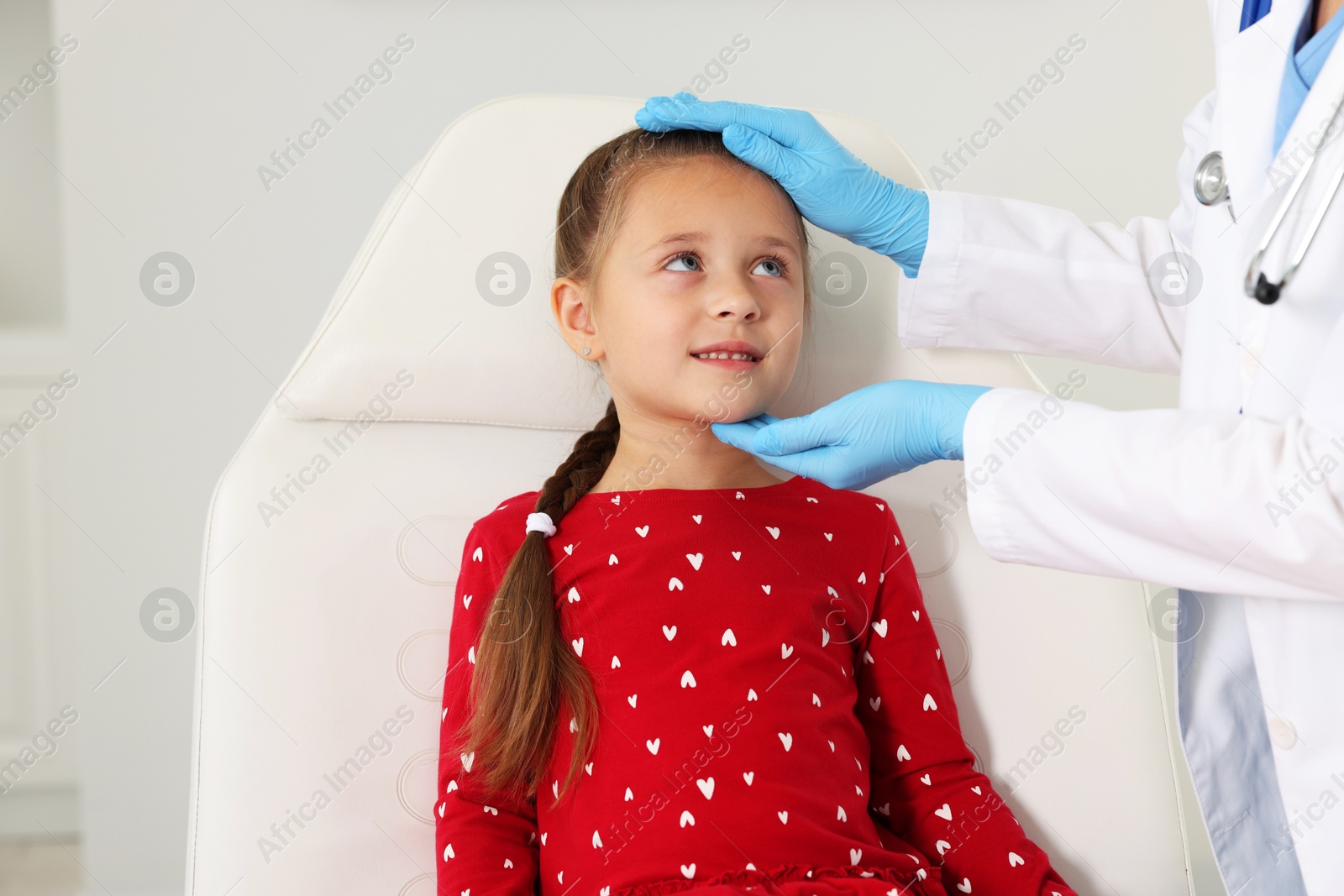 Photo of Doctor examining girl's throat in clinic during appointment