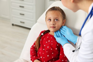 Photo of Doctor examining girl's throat in clinic during appointment