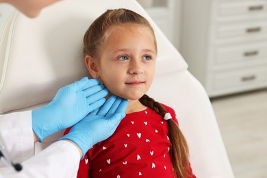 Photo of Doctor examining girl's throat in clinic during appointment