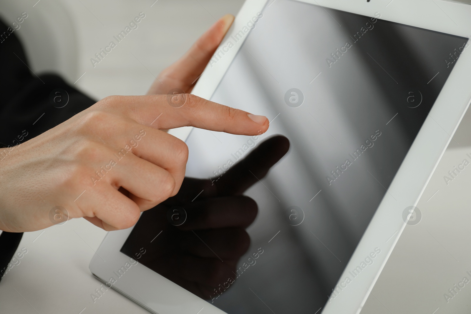 Photo of Businesswoman using tablet at white table indoors, closeup. Modern technology