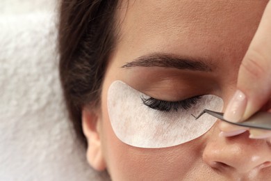 Photo of Woman undergoing lash extensions procedure in beauty salon, top view