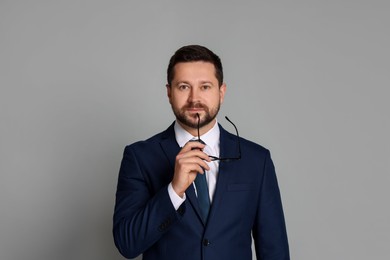 Portrait of banker with glasses on grey background