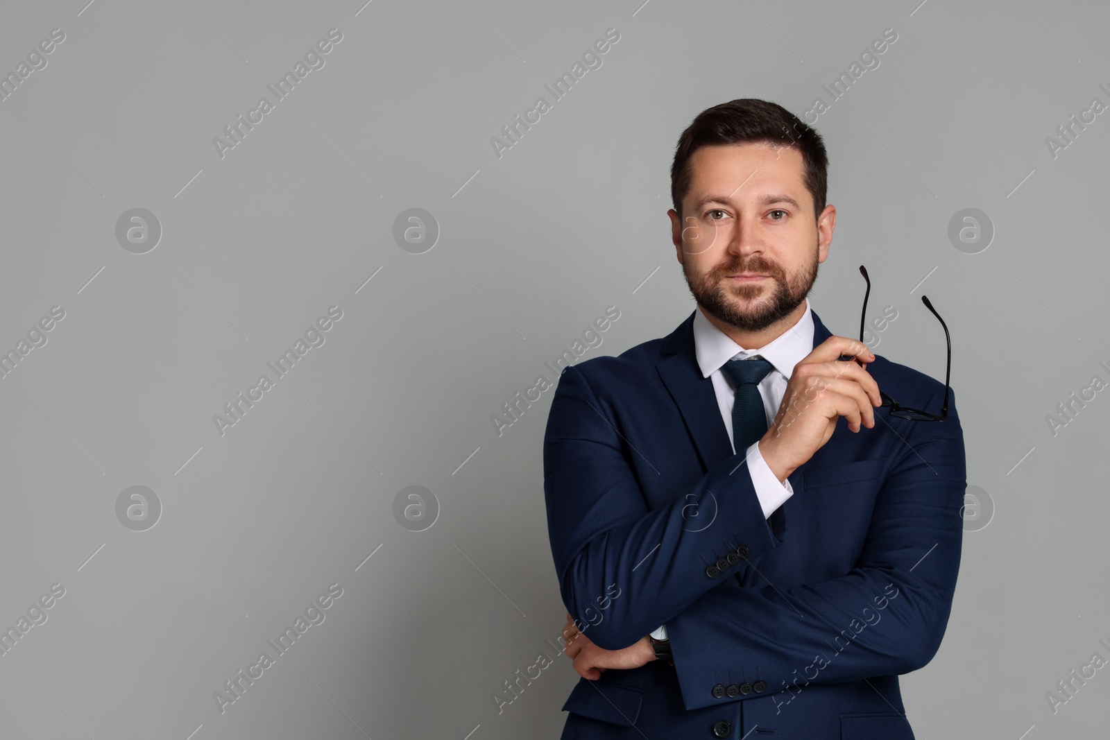 Photo of Portrait of banker with glasses on grey background, space for text