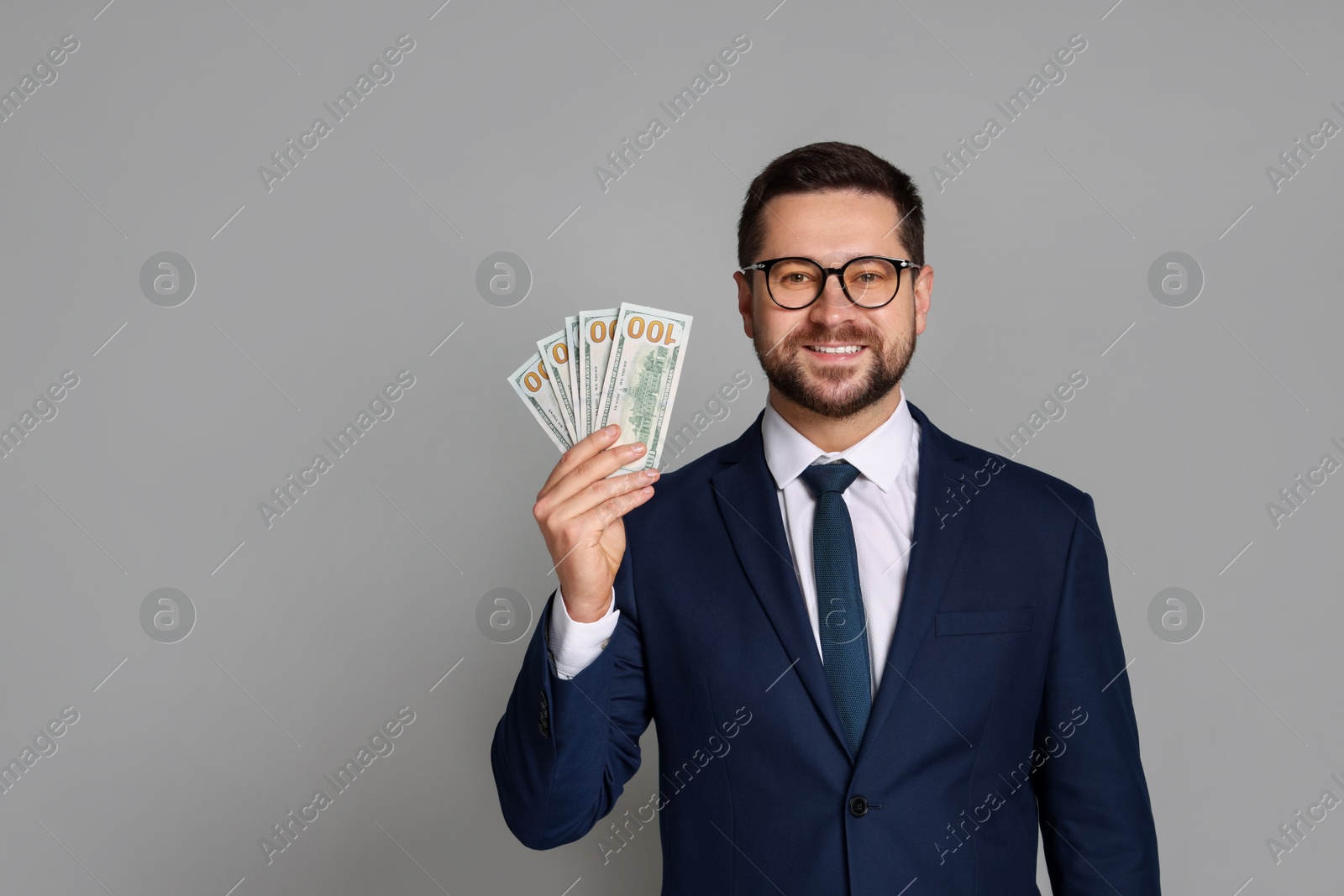 Photo of Portrait of banker with dollar banknotes on grey background, space for text