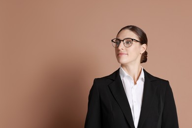 Photo of Portrait of banker in glasses on brown background, space for text