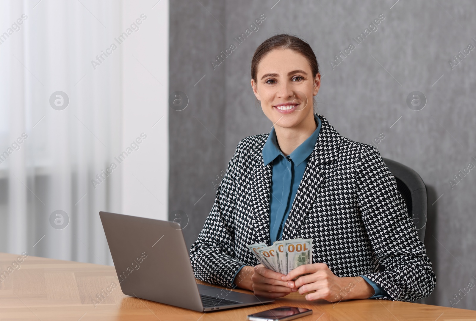 Photo of Banker with dollar banknotes at wooden table in office