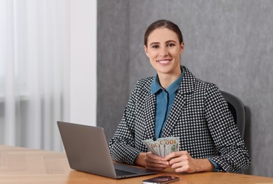 Photo of Banker with dollar banknotes at wooden table in office