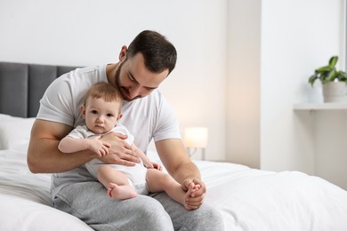 Photo of Father with his little baby on bed at home. Space for text