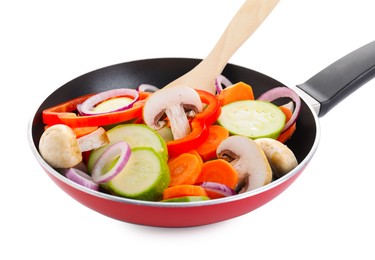 Photo of Frying pan with mix of fresh vegetables, mushrooms and spatula isolated on white