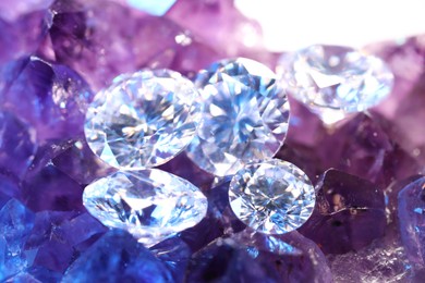 Photo of Beautiful shiny gemstones on natural amethyst, closeup