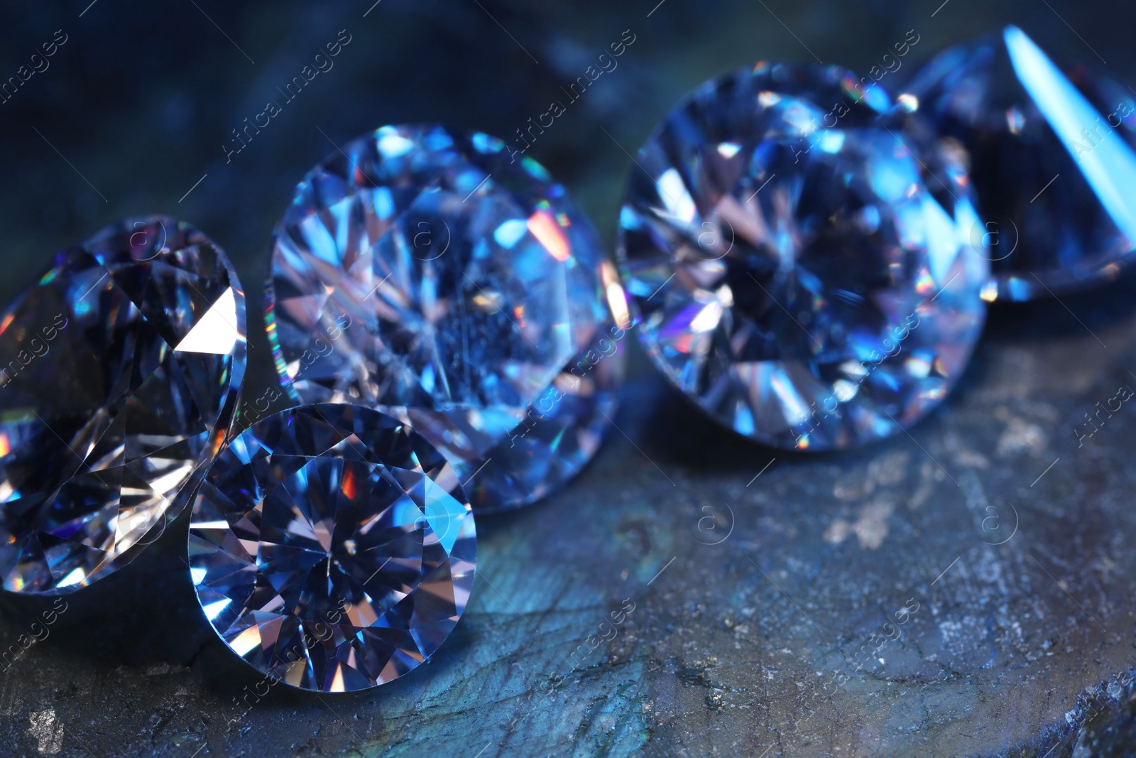 Photo of Beautiful shiny gemstones on stone, closeup view