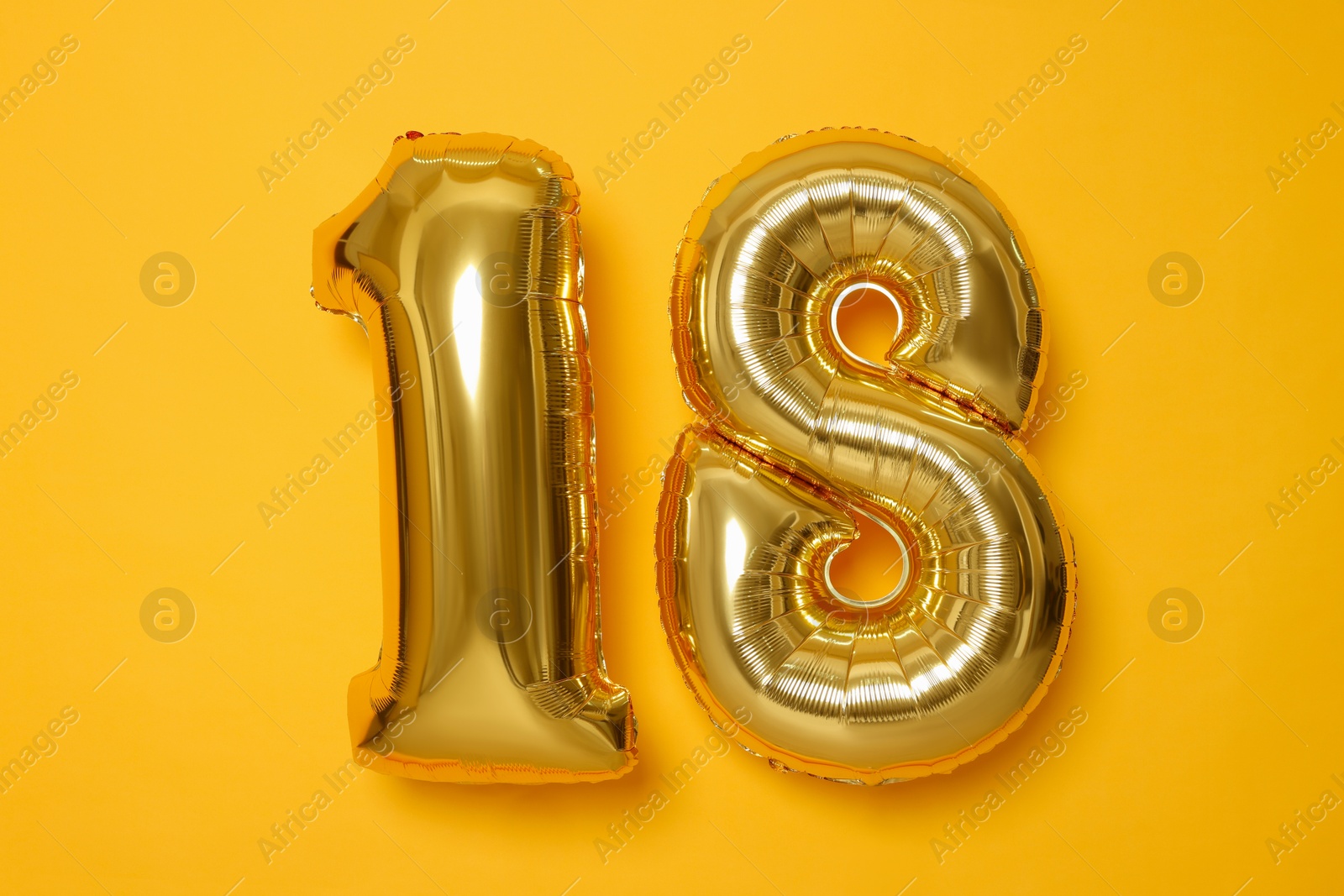 Photo of 18th birthday, coming of age party. Number shaped balloons on orange background