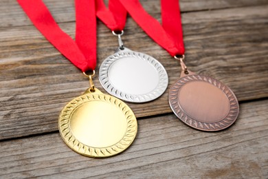 Photo of Golden, silver and bronze medals on wooden background, closeup