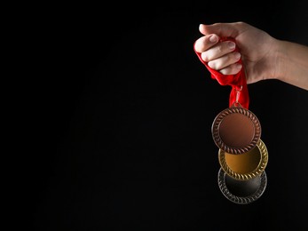 Photo of Woman with different medals on black background, closeup. Space for text