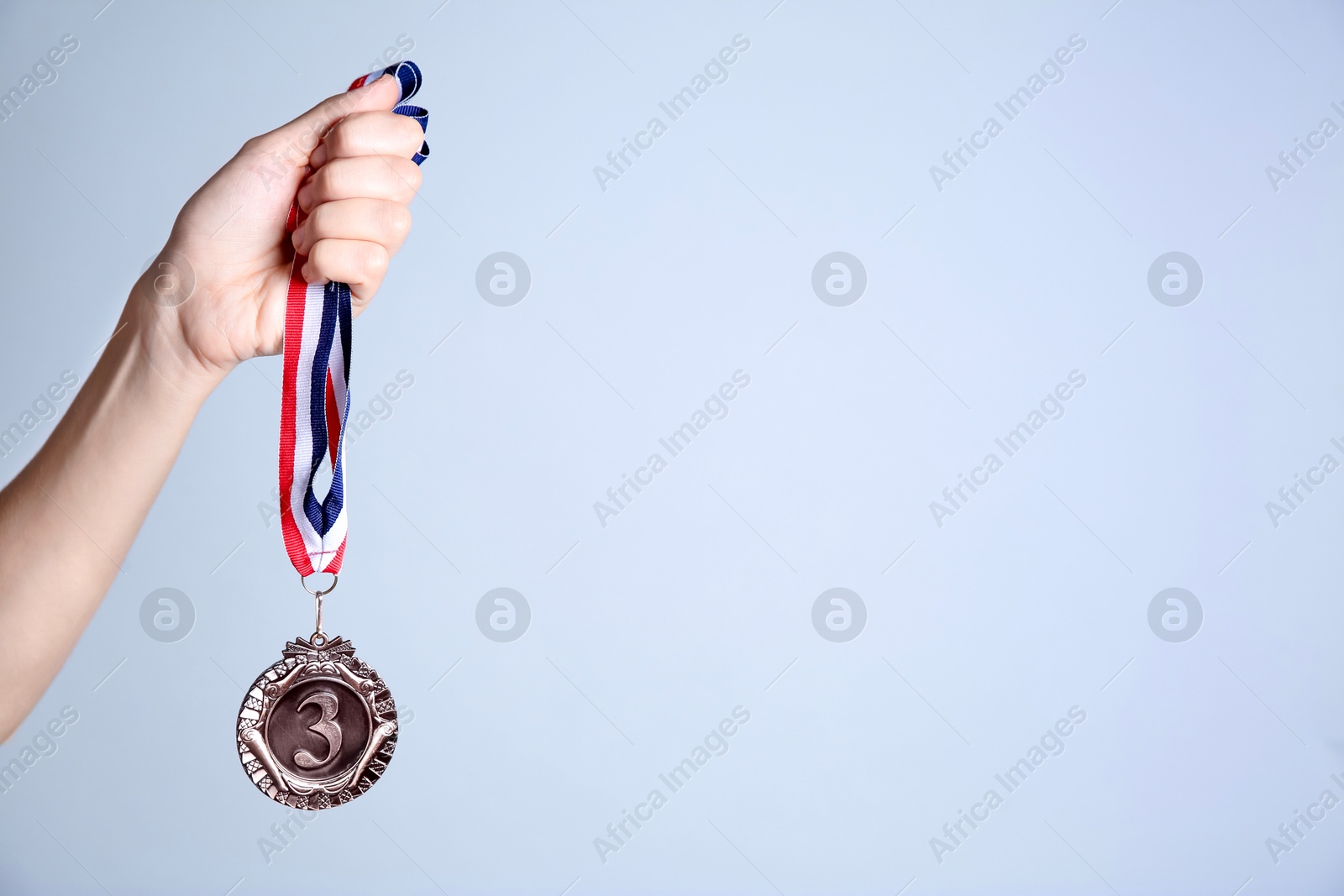 Photo of Woman with bronze medal on grey background, closeup. Space for text