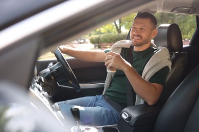 Photo of Man with cup of coffee driving modern car