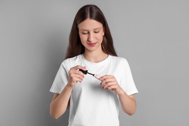 Photo of Teenage girl with mascara on grey background