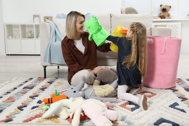 Little helper. Daughter and mother putting away toys together at home