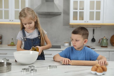 Little helpers. Children making dough for cookies in kitchen at home