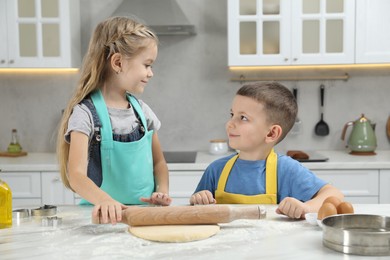 Little helpers. Children making cookies in kitchen at home