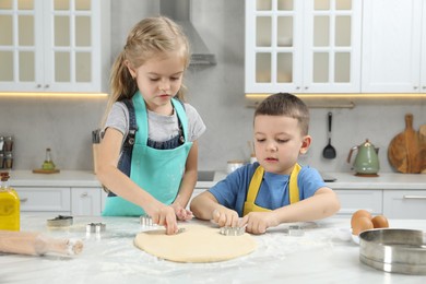 Little helpers. Children making cookies in kitchen at home