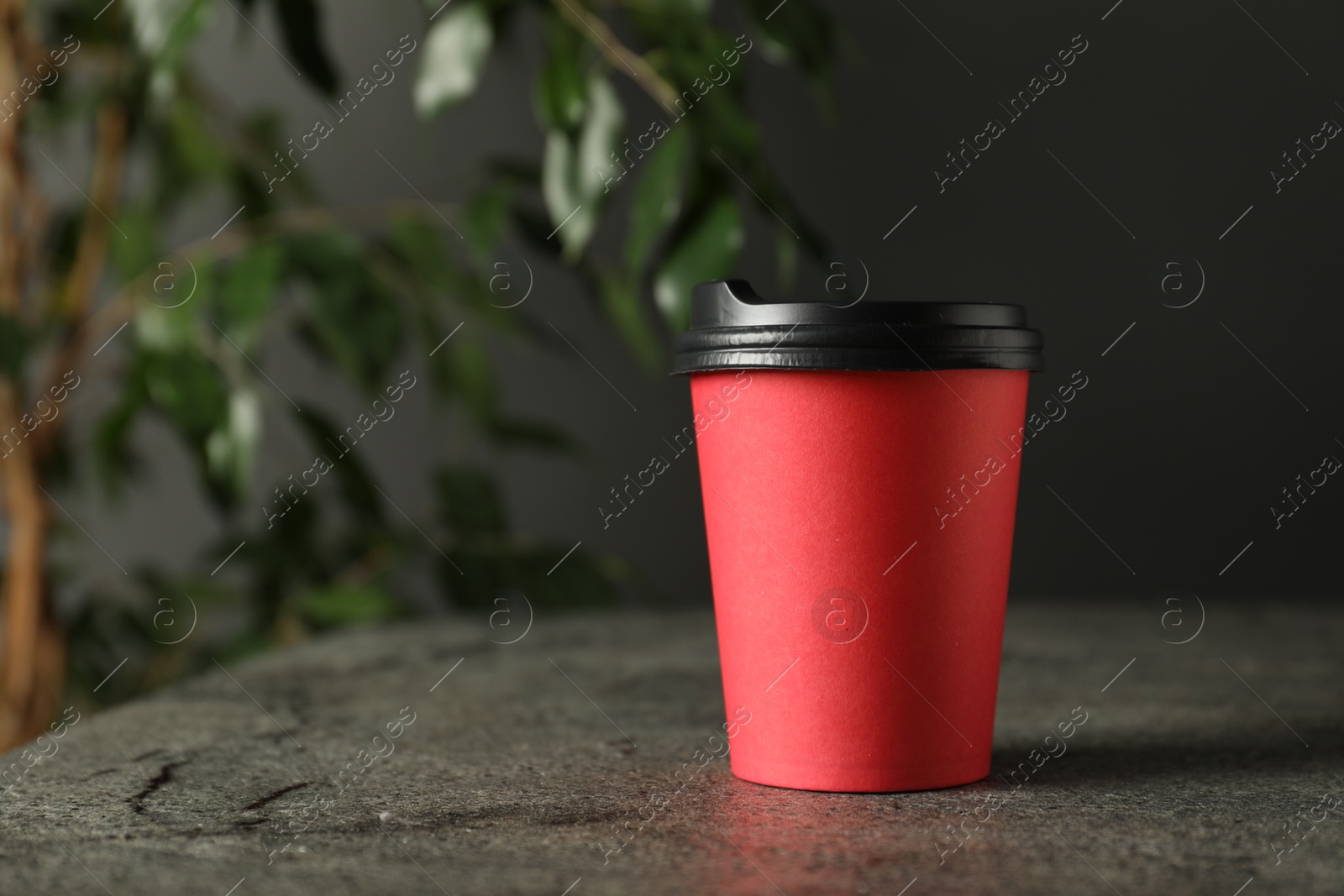 Photo of Paper cup on grey textured table indoors, closeup. Mockup for design