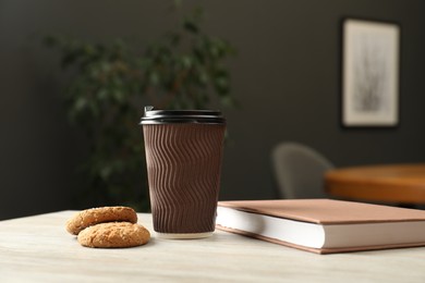 Photo of Paper cup, book and cookies on light wooden table indoors. Mockup for design