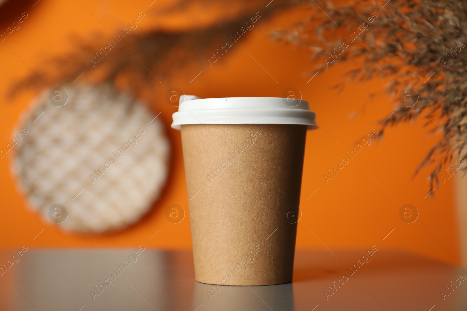 Photo of Paper cup on grey table indoors, closeup. Mockup for design