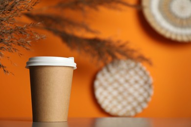 Photo of Paper cup on grey table indoors, closeup. Mockup for design