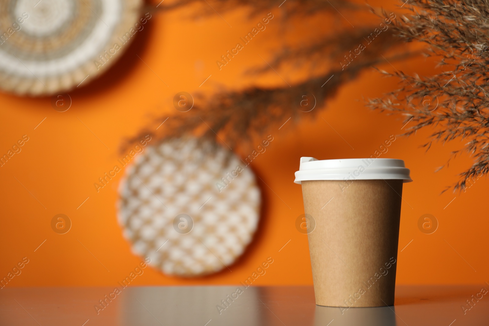 Photo of Paper cup on grey table indoors. Mockup for design