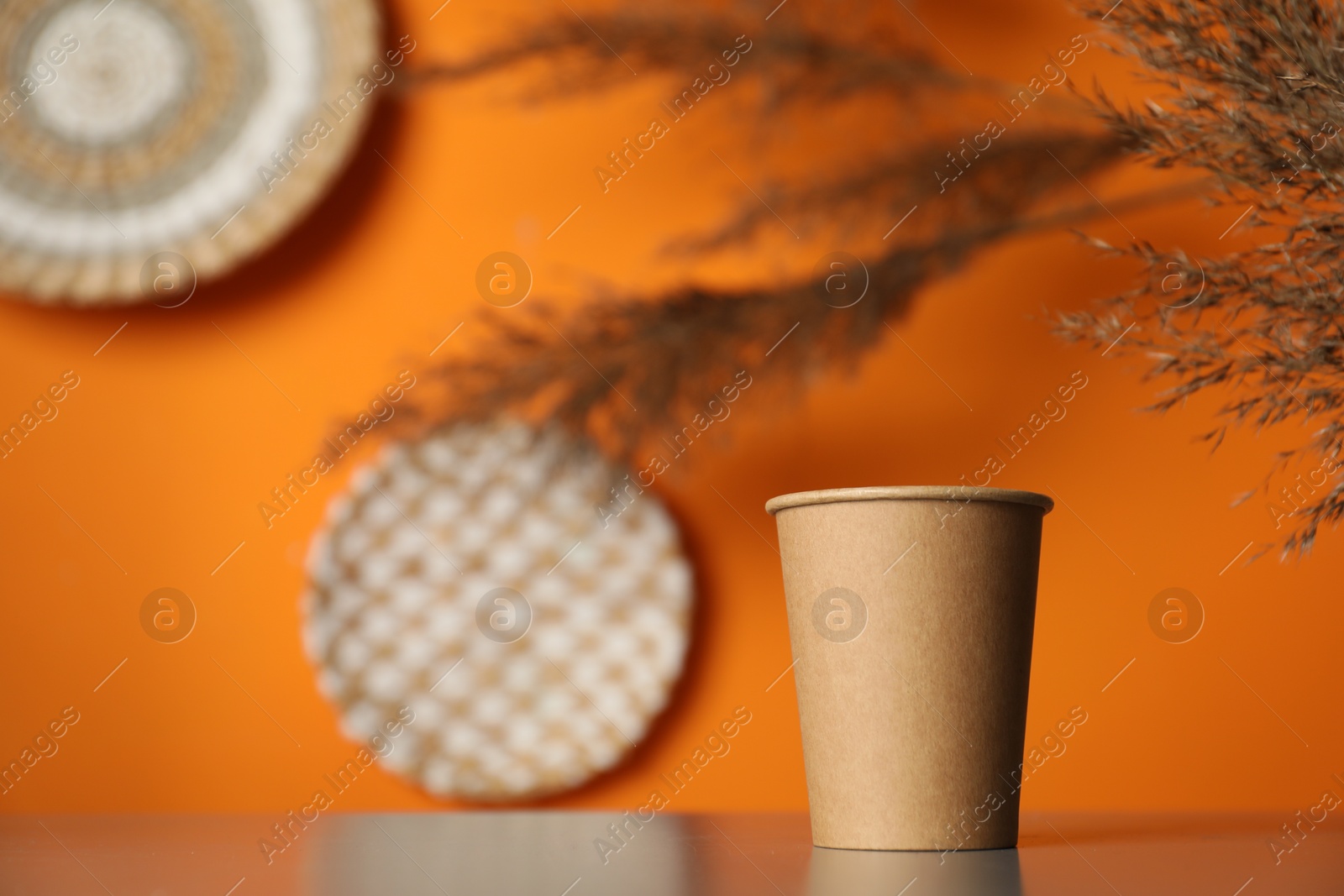 Photo of Paper cup on grey table indoors. Mockup for design