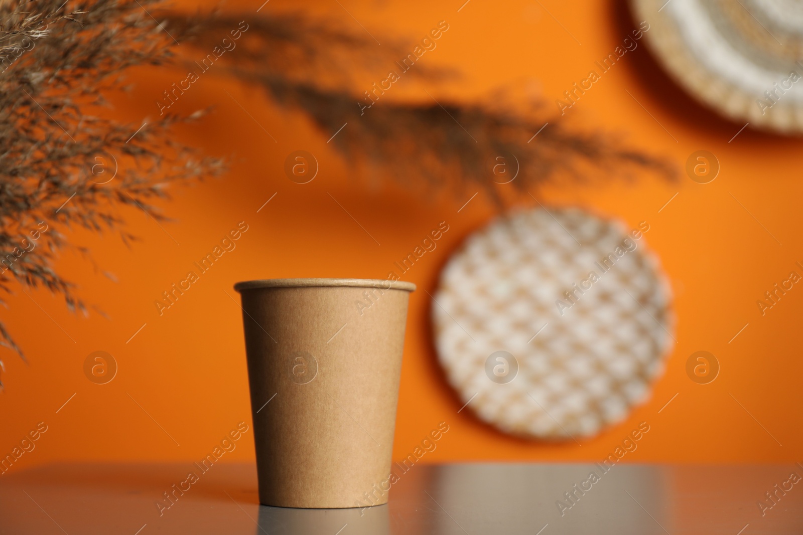 Photo of Paper cup on grey table indoors. Mockup for design